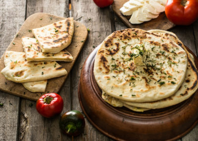 Pita Bread On Wooden Board With Feta Cheese And Tomatoes And Pep
